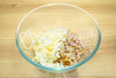 У миску нарізати кубиками яйця та курку.